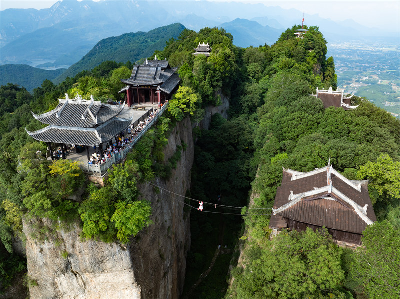 Kutazama maonyesho ya watembea angani kwenye mnyororo wa chuma ulioko?kati ya?vilele viwili virefu vya Mlima Douqi, Mkoani?Sichuan, China